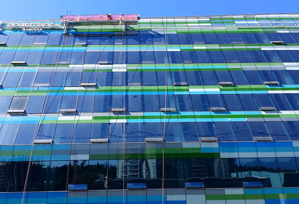 Gruen und blau gestreifte Glasfassade eines modernen Gebaeudes