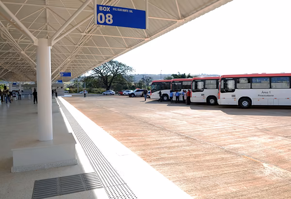 Busse an einem ueberdachten Haltebereich mit offenem Vorplatz